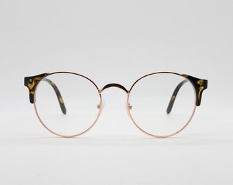 90s vintage modified cat eye glasses. Tortoise arms with a round gold face. 40s, 50s style clear lens eyeglasses. Cateye