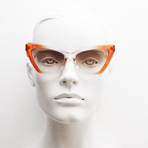 Vintage oversized pointed cat eye sunglasses. Dramatic orange and crystal ombre frame with light tone lenses. NOS