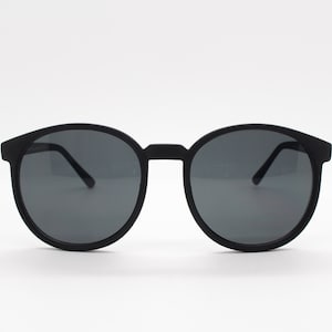 80s vintage round sunglasses. Slightly oversized slim black frame in a rubber finish with matching lenses. Unworn. BNWT