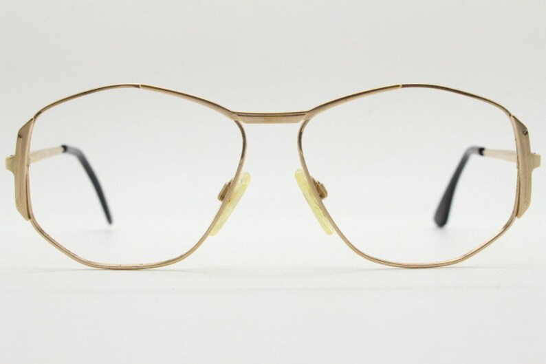 Puede incluir: Gafas de metal doradas con montura octogonal geom&eacute;trica y lentes transparentes.