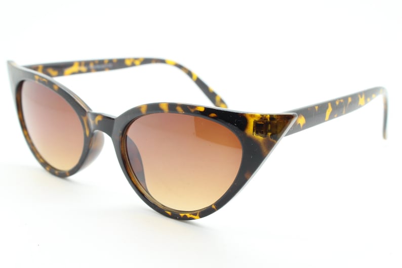 May include: Tortoise shell cat eye sunglasses with brown lenses.