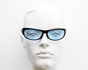 Gafas de sol envolventes curvas vintage de los 90. Montura aerodinámica de perfil bajo con acabado satinado negro y lentes azules claros. Visera deportiva. NOS.