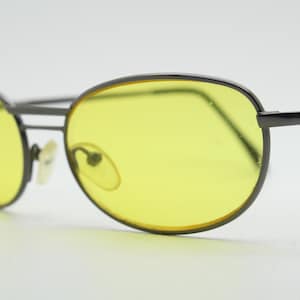 Y2K vintage petites lunettes de soleil ovales bug eye. Monture satinée gris gunmetal avec verres jaune canari flamboyants. Années 2000 inutilisées NOS. 90s micro