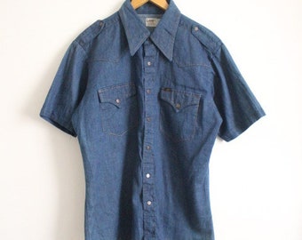 LEE 70s vintage short sleeve mens shirt. Blue denim western design with yolked pockets and back, epaulettes and brass popper buttons. NOS