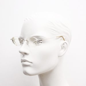 Silhouette frameless oval eye glasses. Extremely minimal lightweight gold titanium optical frame with springy hingeless arms. 2000s Vintage