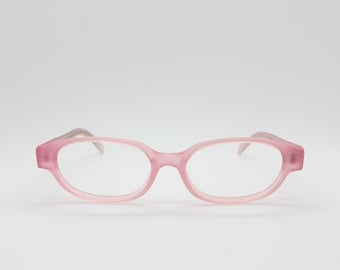 May include: A pair of pink eyeglasses with a rounded rectangular frame. The temples are a lighter shade of pink. The glasses are set against a white background.