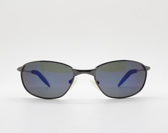 90s vintage curved oval sunglasses. Solid metal low profile frame in grey chrome with slightly mirrored dark lenses. 2000's. Y2K NOS