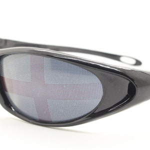 Könnte beinhalten: Schwarze Sonnenbrille mit einem rot-weiß-blauen Flaggenmuster auf den Gläsern.