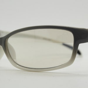 Y2K vintage futuristic sunglasses. Gloss white and grey wrap around shield style frame with light tone lenses. Cosplay visor. 2000s NOS