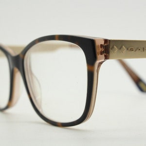May include: Tortoiseshell eyeglasses with gold accents and the word "GANT" on the side.
