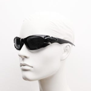 90s vintage sports shield sunglasses. All black gloss aerodynamic wraparound with many stylised features. 2000&#39;s. Hells angel uber fashion