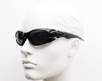 90s vintage sports shield sunglasses. All black gloss aerodynamic wraparound with many stylised features. 2000's. Hells angel uber fashion