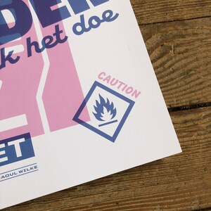 K&ouml;nnte beinhalten: Ein wei&szlig;er Poster mit blauem und rosafarbenem Text, der "Untersch&auml;tze niemals die Kraft dessen, was du tun kannst" lautet. Der Poster hat auch ein blaues Warnschild mit einem Flammensymbol.