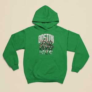 Puede incluir: Sudadera con capucha verde con un gráfico de un equipo de baloncesto que lleva uniformes verdes y blancos. El texto "BOSTON" está por encima del equipo.