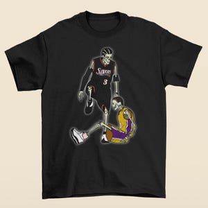 Puede incluir: Camiseta negra con un gráfico de dos jugadores de baloncesto, uno con una camiseta de los Sixers en blanco y negro y el otro con una camiseta de los Lakers en morado y dorado. Ambos jugadores son esqueletos.