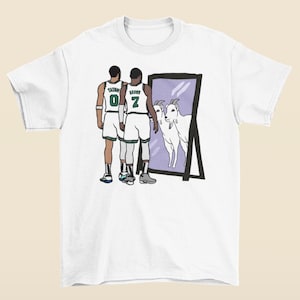 Puede incluir: Camiseta blanca con un gráfico de dos jugadores de baloncesto mirando en un espejo que refleja dos cabras. Los jugadores llevan camisetas verdes y blancas con los nombres "TATUM" y "BROWN" y los números "0" y "7" en la espalda.