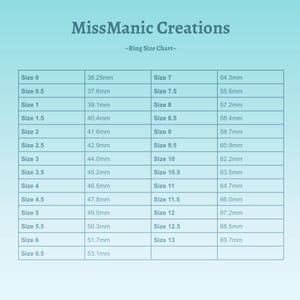 May include: A ring size chart from MissManic Creations. The chart is on a light blue background and lists ring sizes from 0 to 13, with corresponding millimeter measurements. The text "-Ring Size Chart-" is above the chart.