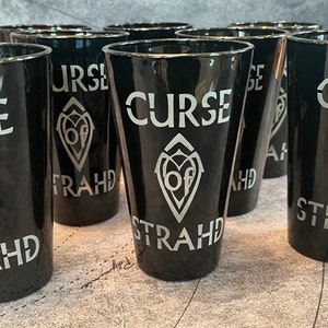 Könnte beinhalten: Acht schwarze Plastikbecher mit silbernem Design und dem aufgedruckten Text "Curse of Strahd".