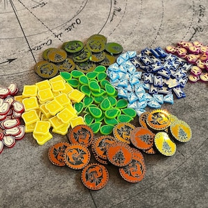 May include: A collection of colorful game pieces, including green leaves, blue and white geometric shapes, yellow squares, red and white meat shapes, and orange and black dragon-like designs.