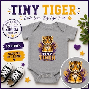 May include: A heather grey short-sleeved baby bodysuit featuring a graphic of a tiger cub wearing a bow tie, with the text "TINY TIGER" below. The design includes purple and yellow accents, and the bodysuit is surrounded by text and icons.