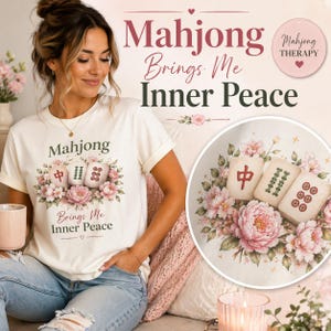 May include: Cream-colored t-shirt with a floral design and the words "Mahjong Brings Me Inner Peace." The design includes Mahjong tiles and pink flowers. The image also shows a decorative plate with Mahjong tiles and flowers.
