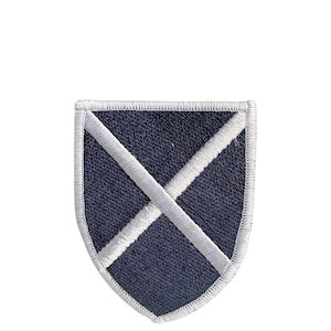 Può includere: Toppa ricamata blu navy a forma di scudo con un design a X bianco cucito. La toppa ha un bordo bianco ed è posta su uno sfondo bianco. Questa toppa è adatta per giacche, borse o altri articoli in tessuto.