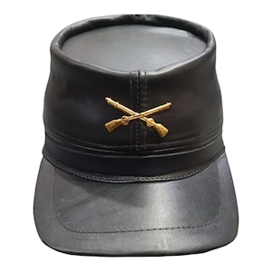 May include: A black leather military-style cap with a gold crossed rifles insignia.