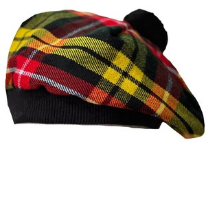 May include: A black and red tartan beret with a black pom-pom on top.