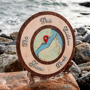May include: A wooden circular puzzle with a map of Lake Como, Italy in the center. The puzzle pieces are labeled with the words "Date", "Bride", "Groom", "Pets", and "Children".