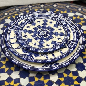 Peut inclure: Un ensemble de trois assiettes en céramique bleu et blanc avec un motif géométrique. Les assiettes sont empilées les unes sur les autres et ont un fond blanc avec un motif géométrique bleu.