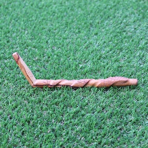 Könnte beinhalten: Eine Holzpfeife mit einem geschnitzten Design. Die Pfeife ist gebogen und hat eine braune Farbe.