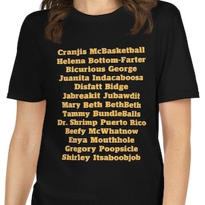 May include: Black t-shirt with a list of names printed in gold on the front. The names include Cranjis McBasketball, Helena Bottom-Farter, Bicurious George, Juanita Indacaboosa, Disfatt Bidge, Jabreakit Jubawdit, Mary Beth BethBeth, Tammy BundleBalls, Dr. Shrimp Puerto Rico, Beefy McWhatnow, Enya Mouthhole, Gregory Poopsicle, and Shirley Itsaboobjob.