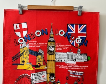 May include: Red tea towel featuring iconic London landmarks including Big Ben, Tower Bridge, Buckingham Palace, and the London Eye. The text "LONDON" is printed in large letters on the towel.