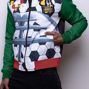 May include: A white, green, and red bomber jacket with a soccer ball pattern and a patch that says "Forward Ever Backward Never".