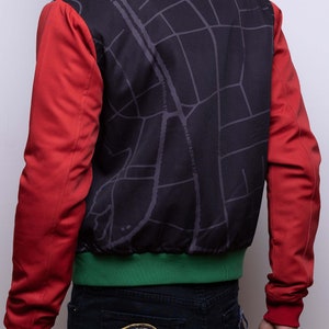 May include: A red, green, and black bomber jacket with a map design on the back. The map design includes the text "54 KINGDOMS 2022".