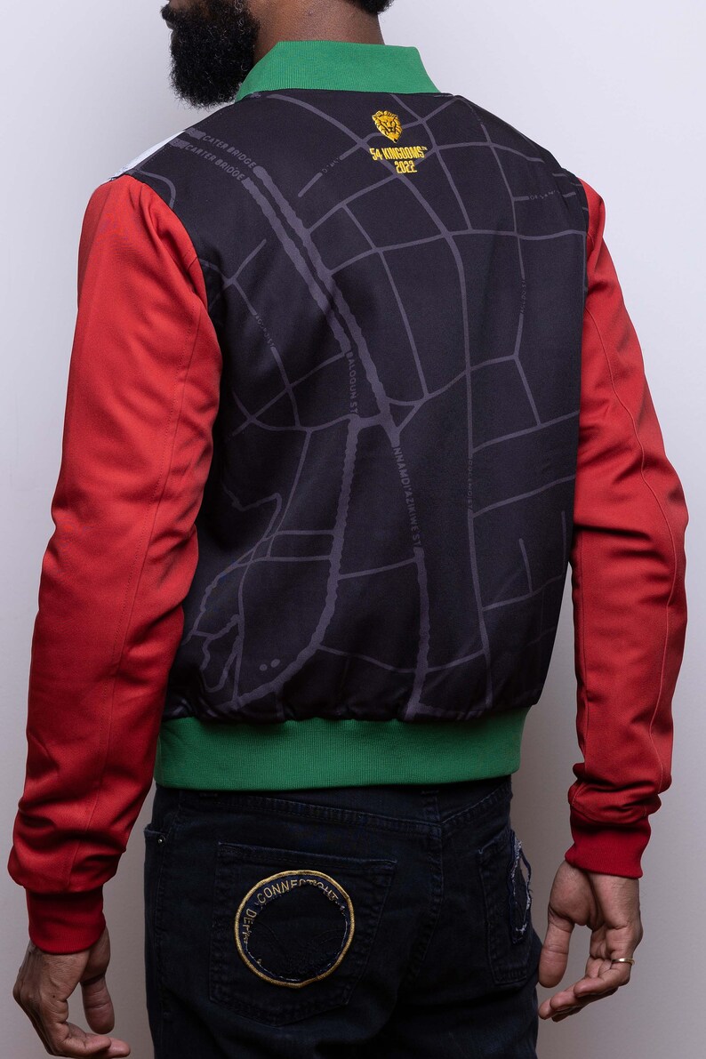 May include: A red, green, and black bomber jacket with a map design on the back. The map design includes the text "54 KINGDOMS 2022".