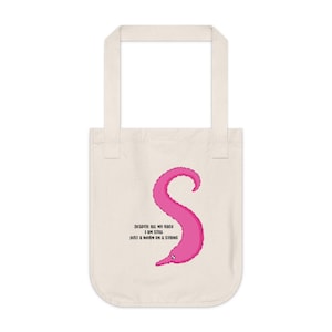 May include: A pink worm on a string tote bag with the text "Despite all my rage I am still just a worm on a string."