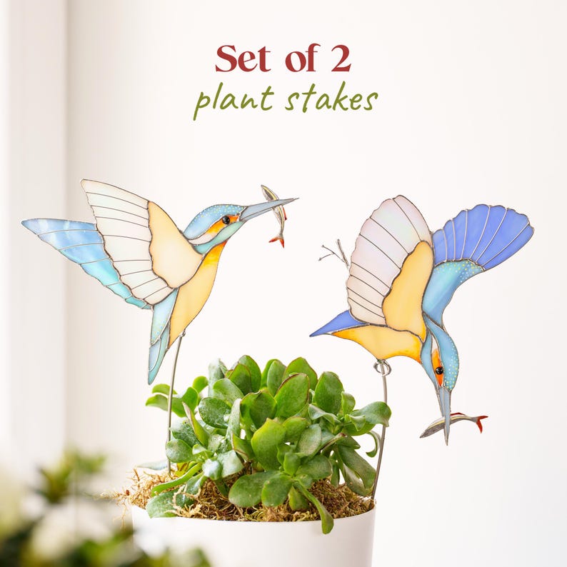 Handcrafted stained glass kingfisher bird used as an indoor plant stake in a potted succulent. Vibrant blue and orange Tiffany technique suncatcher. Botanical room decor and houseplant accessory. Unique gift for bird watchers and plant lovers. Available with a minimalist white faux stone base.