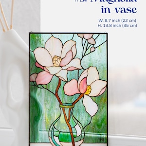 Puede incluir: Panel de vidriera con una magnolia en un jarr&oacute;n. La obra presenta un fondo verde y blanco con flores de magnolia rosas y blancas. El panel mide 22 cm de ancho y 35 cm de alto.