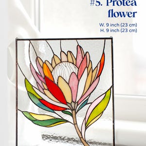 Puede incluir: Un panel de vidrieras con un dise&ntilde;o de flor de protea colorido. La obra de arte incluye tonos de rosa, rojo, amarillo y verde, con un tallo y hojas marrones. El panel mide 23 cm de ancho y 23 cm de alto, con el texto "#5. Protea flower".