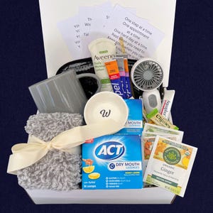 Peut inclure: Coffret cadeau de soins personnels contenant une tasse grise, un petit ventilateur, de la lotion, du baume &agrave; l&egrave;vres, des pastilles, du th&eacute;, un petit bol avec un "W", une couverture grise et des notes inspirantes.