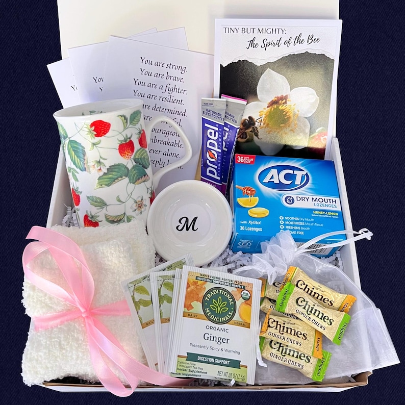 Puede incluir: Caja de regalo con art&iacute;culos de cuidado personal. Incluye una taza decorada con fresas, un cuenco peque&ntilde;o con la letra "M", bolsitas de t&eacute;, caramelos de jengibre, un pa&ntilde;o con una cinta rosa y una tarjeta con texto inspirador.