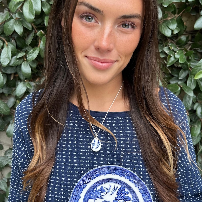 Woman wearing Blue Willow love bird necklace handmade with vintage china and sterling silver, a romantic gift for 9th, 18th, 20th anniversary.