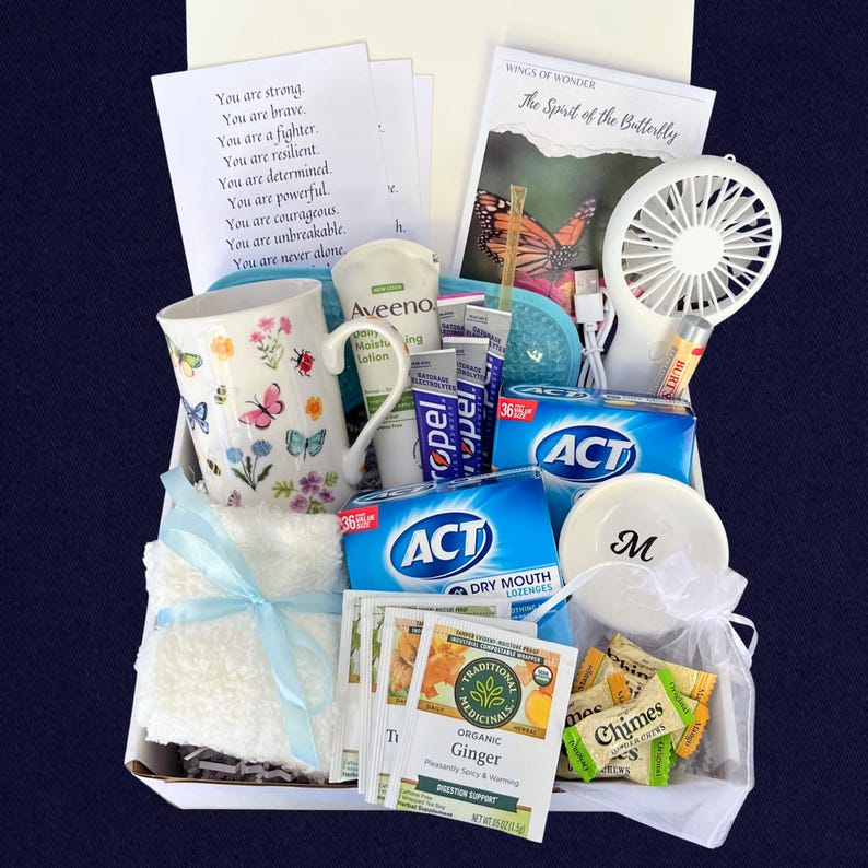 Puede incluir: Una cesta de regalo llena de art&iacute;culos de cuidado personal. Incluye una taza floral, loci&oacute;n Aveeno, pastillas para la boca seca ACT, t&eacute; de jengibre, un ventilador peque&ntilde;o, b&aacute;lsamo labial y una tarjeta con texto inspirador. Tambi&eacute;n se incluye una tapa blanca con la letra "M".