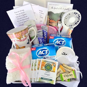 Puede incluir: Una cesta de regalo llena de art&iacute;culos de cuidado personal. Incluye una taza de t&eacute; floral, un peque&ntilde;o ventilador blanco, pastillas para la boca seca ACT, t&eacute; de jengibre, una toalla peque&ntilde;a con una cinta rosa y notas inspiradoras.