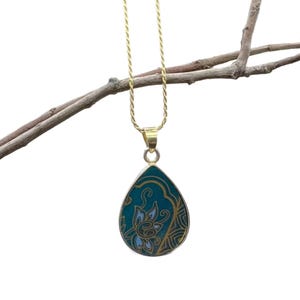 K&ouml;nnte beinhalten: Eine goldene Kettenkette mit einem tropfenf&ouml;rmigen Anh&auml;nger. Der Anh&auml;nger ist aus gr&uuml;nem Stein mit einem goldenen Blumendesign.