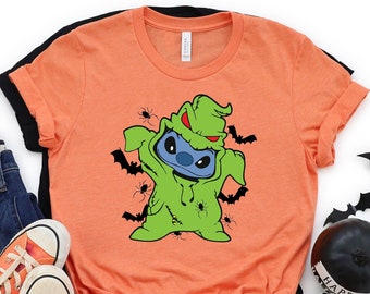 May include: Orange t-shirt featuring a green Stitch character dressed as the Grinch. The character is surrounded by bats and spiders.