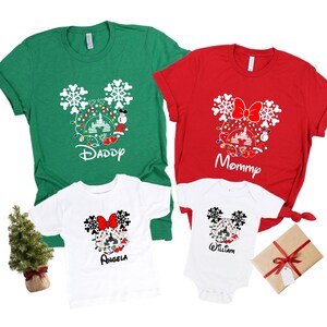 May include: A set of four Christmas themed t-shirts featuring a Mickey Mouse head design with a Christmas tree, ornaments, and lights. The shirts are green, red, and white with the words "Daddy", "Mommy", "Angela", and "William" printed on them.
