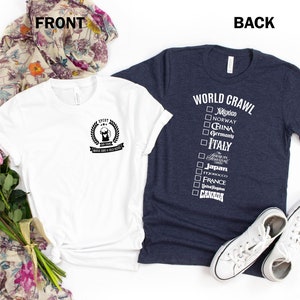 May include: Two t-shirts, one white and one dark blue. The white t-shirt has a black graphic of a beer mug with the text "I've Tried" and "World Crawl & Chill Vibes". The dark blue t-shirt has the text "WORLD CRAWL" and a checklist of countries with checkboxes.