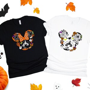 May include: Two t-shirts with a Halloween Mickey Mouse design. The black t-shirt has an orange and black Mickey Mouse head with a bow and the white t-shirt has a black and white Mickey Mouse head with a bow.